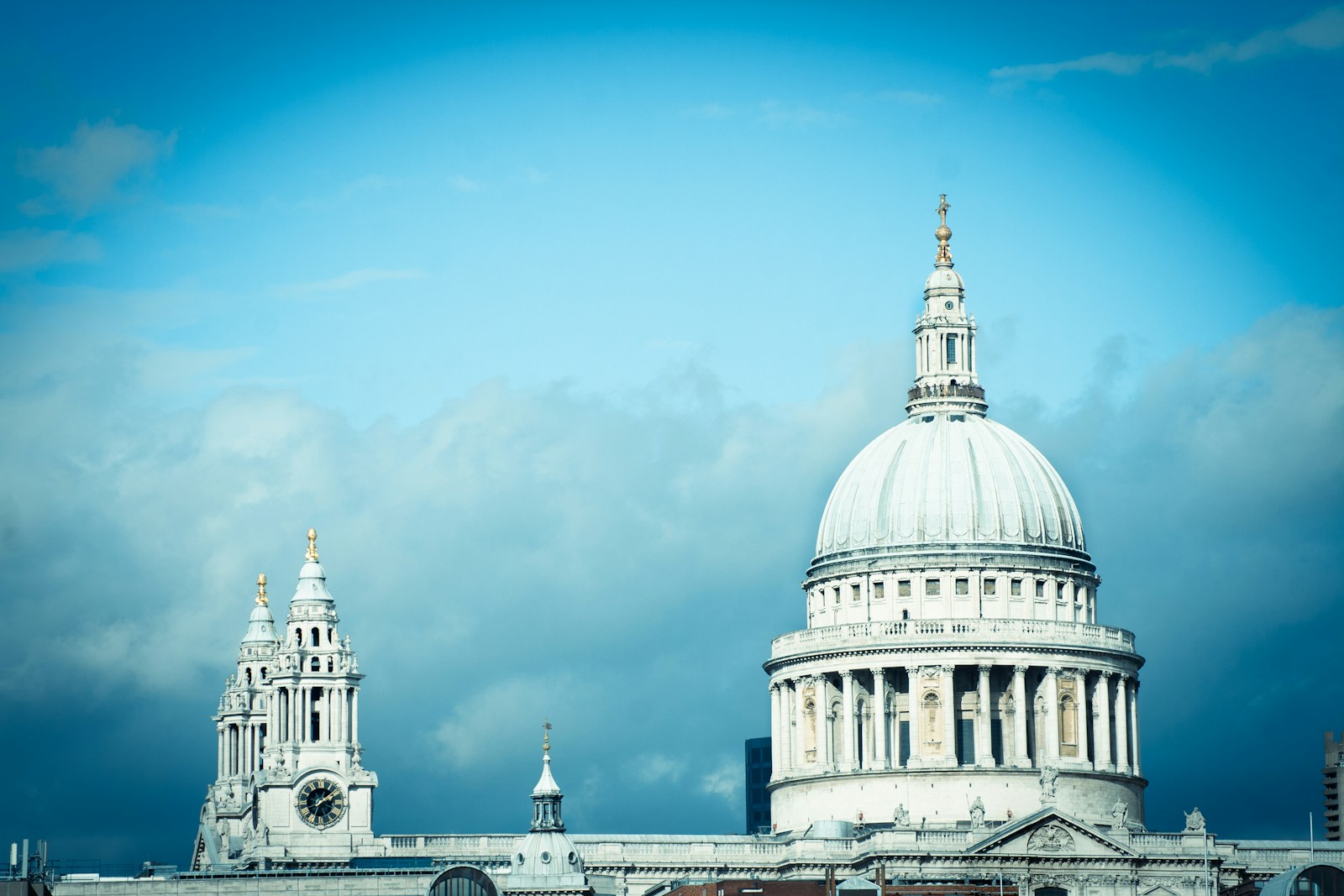 The dome and spires of St. Pauls Cathedral against a blue sky