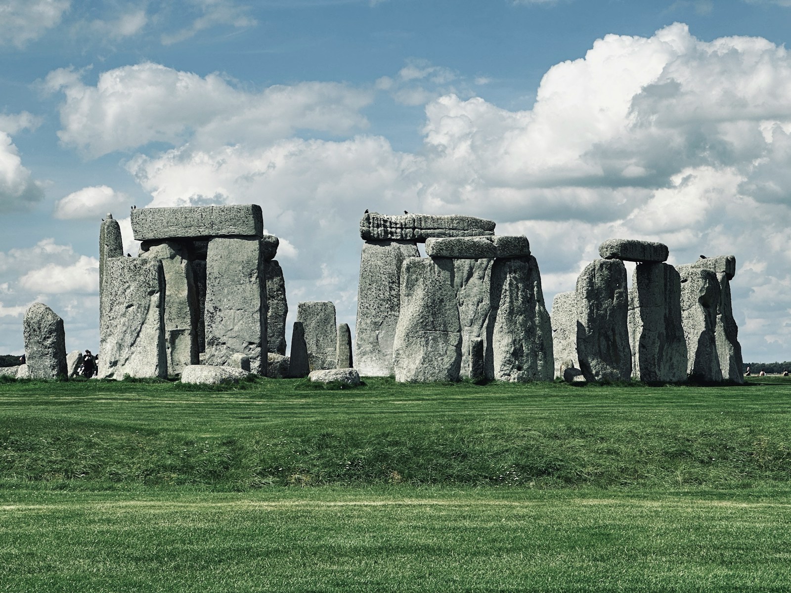 The stones at Stonehenge situated in a circle in the middle of a field.