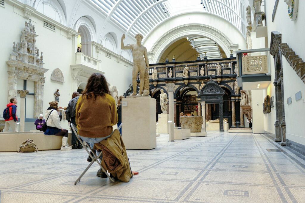 A woman sitting on a chair looking at the exhibits in a museum
