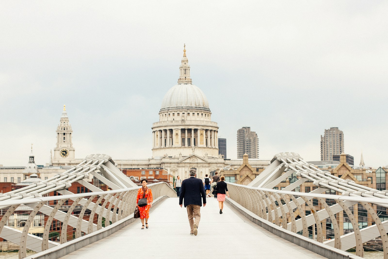 people walking across the Millennium Bridge in London towards St. Paul's Cathedral.