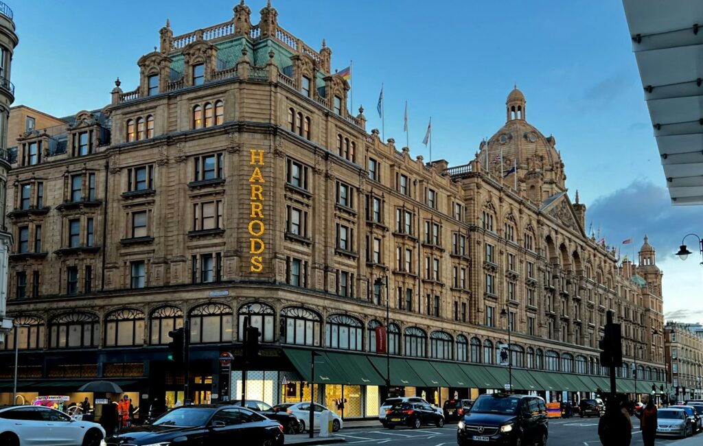 Harrods department store with a black cab driving past