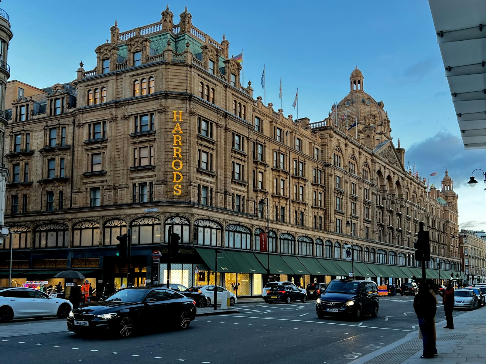 Harrods department store with a black cab driving past