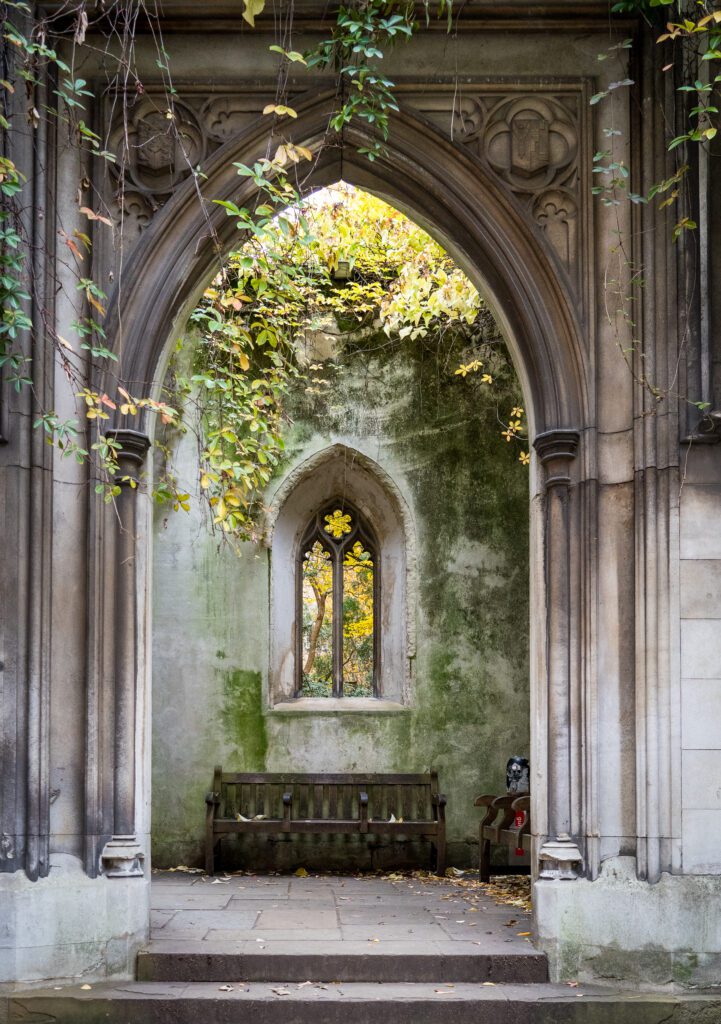 Stone archway leading to a lobby ruins with bench seats