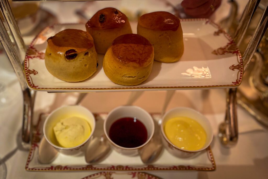 Scones on a serving plate with cream, jam and lemon curd
