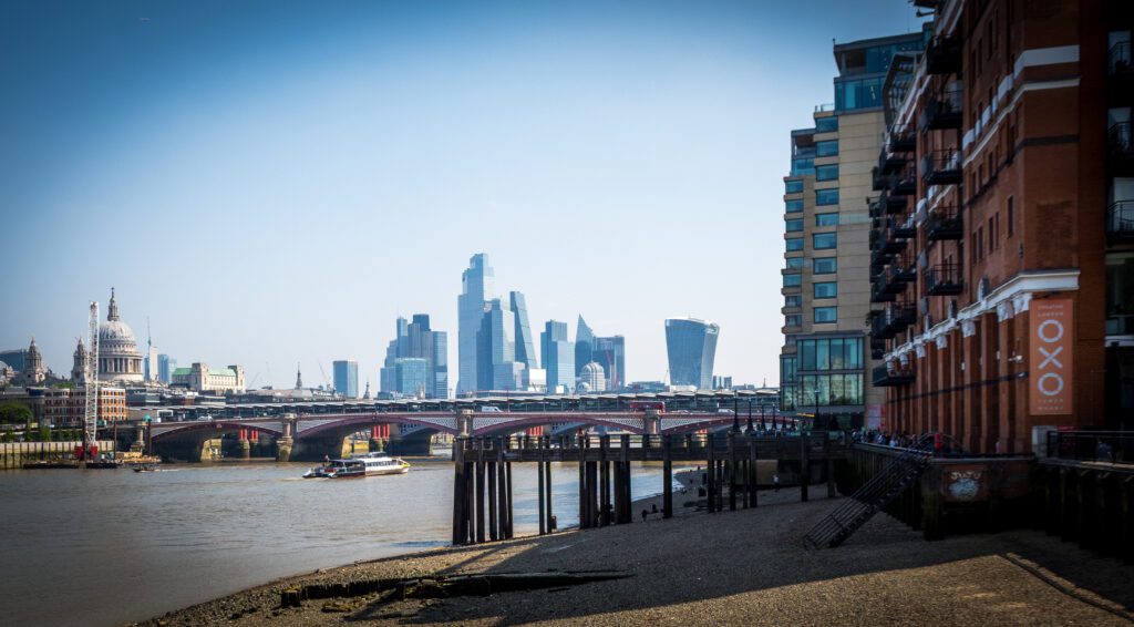 A beach on the River Thames with St. Paul's Cathedral and skyscrapers in the background