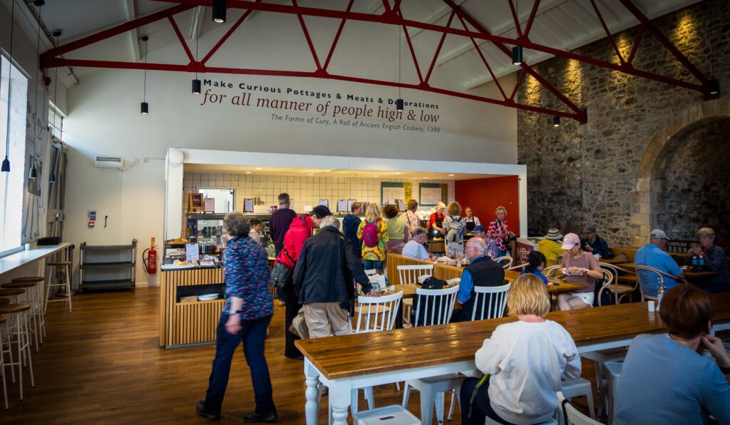 Cafe with tables, chairs and people queueing up at the counter