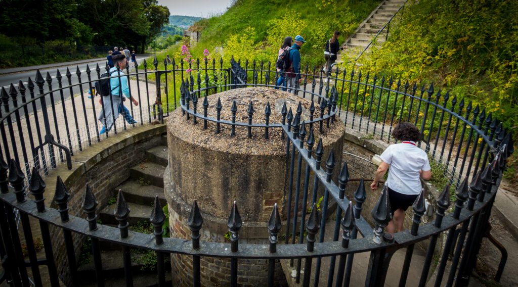 Double helix stone staircase with a fence around it