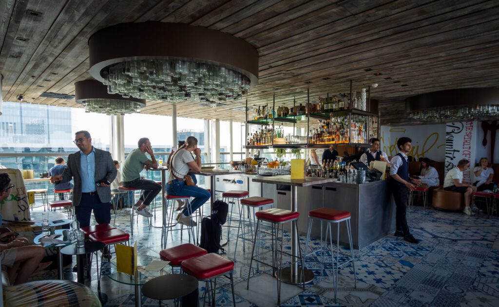 A central bar with tables and stools dotted around the room