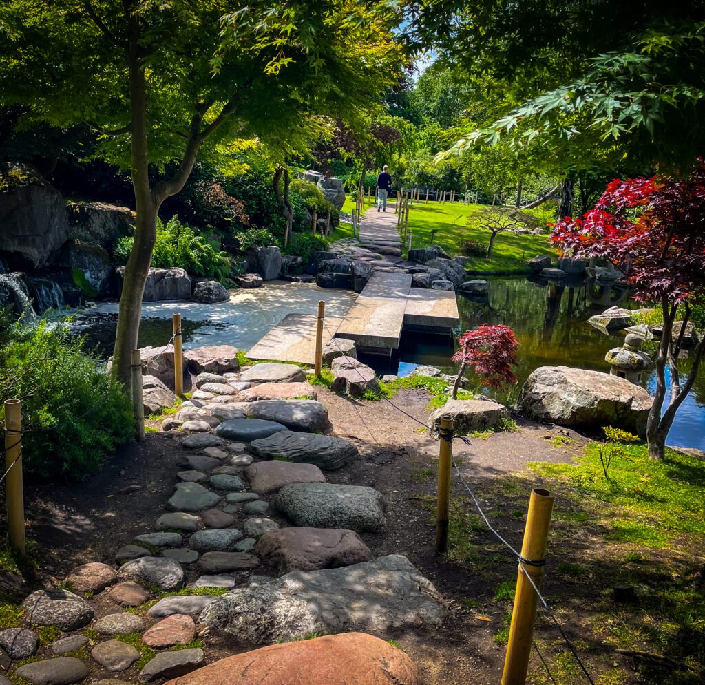 Stone walkway leading to a path across a pond
