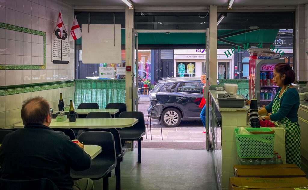 Tables and chairs in Cockney's Pie and mash shop with the counter on the other side