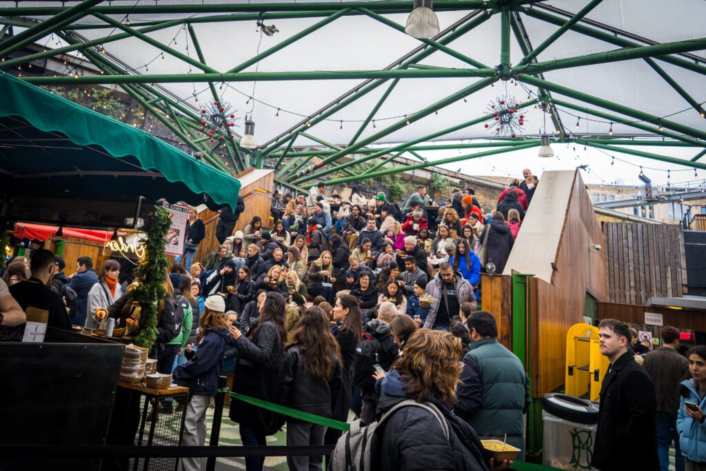Seating Area full of people in the middle of a food market