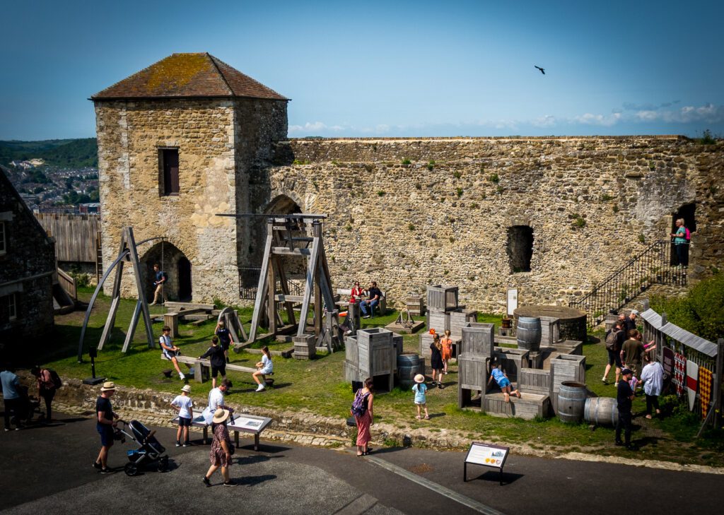 A play are with wooden play equipment inside the castle walls