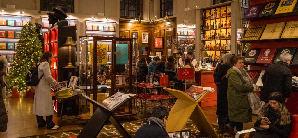 The books on display with the bar inside Maison Assouline
