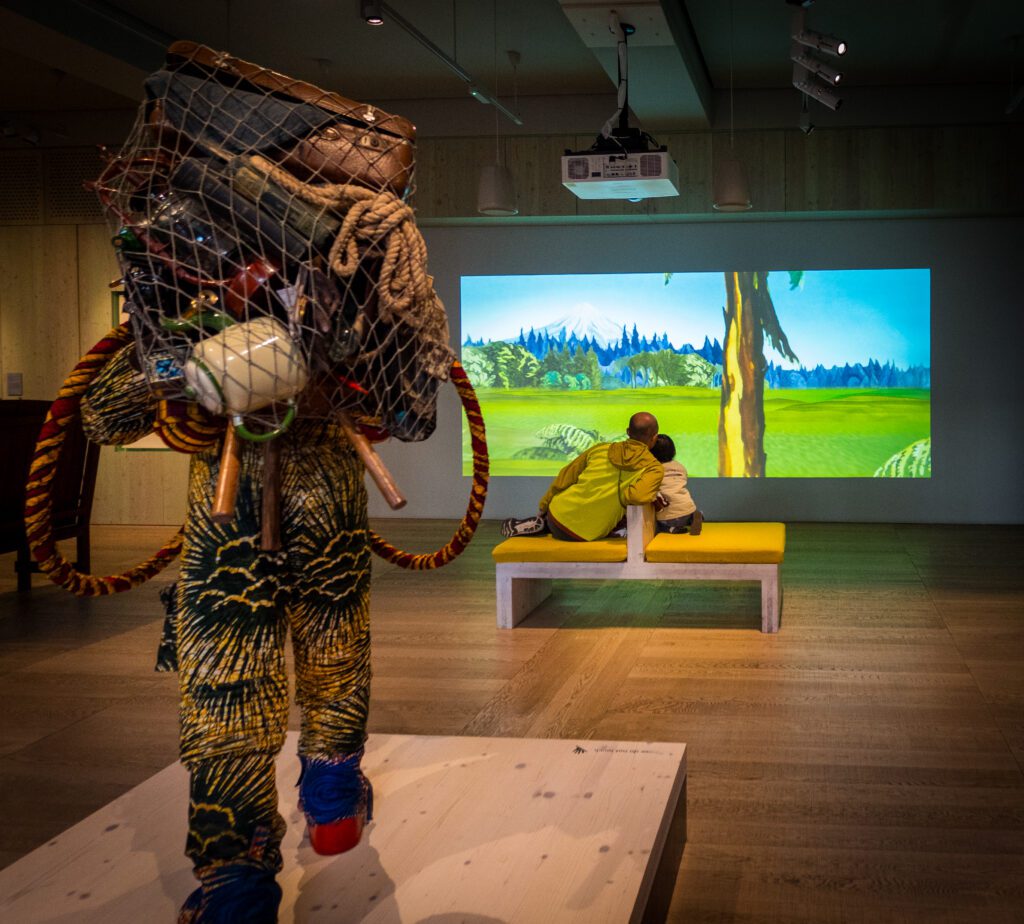 Father and son watching a video in one of The Wellcome Collection's galleries